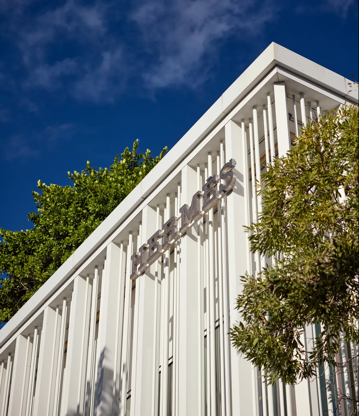 The white Hermès façade under a deep blue sky