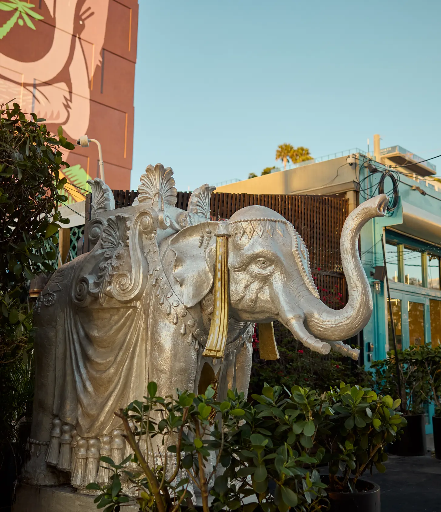 A street with an elephant sculpture and painted storefronts